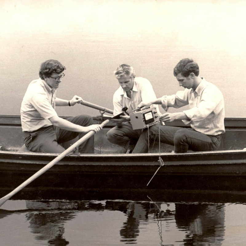 Vintage black and white photo of 3 men in row boat performing research on Lake Lacawac