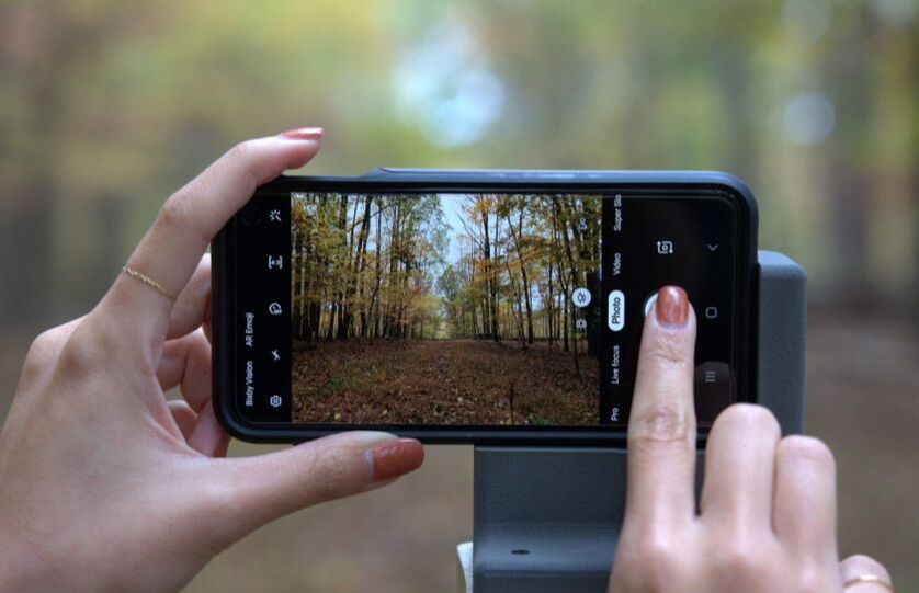 chronolog2 Close up of a person's hand taking photos on a smart phone