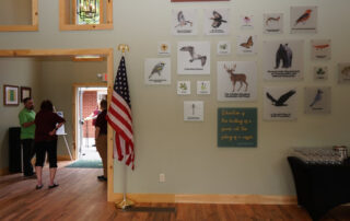 Signs on wall of the center showing local wildlife along with a quote from Socrates that says "Education is the kindling of a flame, not the filling of a vessel."