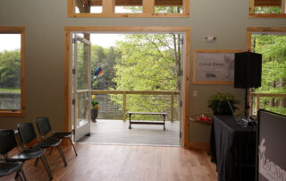 View of the great room inside the Environmental Education Center with doors open to the outside #2