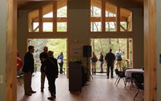 View of the great room inside the Environmental Education Center with doors open to the outside #1
