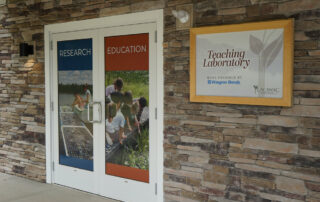 Sign on the outside of the building that says "Teaching Laboratory"