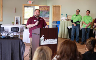 Speaker at the podium addressing the attendees at the ribbon cutting ceremony